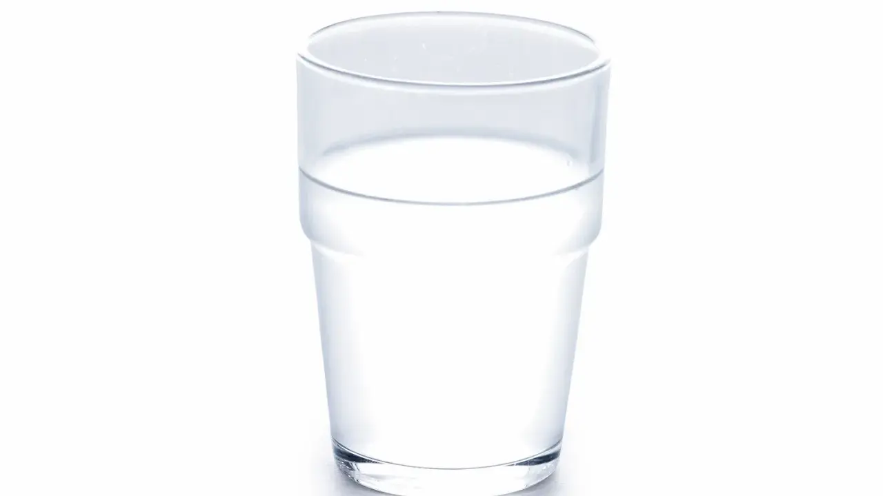 Ett glas med klart vatten, som symboliserar att kokosvatten nyttigt är ett bra val för återfuktning.