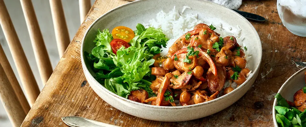 En krämig kycklinggryta med kikärtor och paprika serveras med ris och en fräsch sallad. Perfekt nyttig vardagsmat för hela familjen.