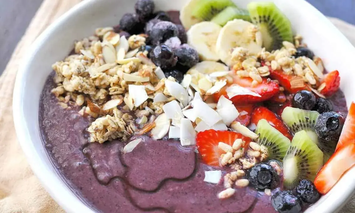 En härlig acai bowl med granola, jordgubbar, blåbär, kiwi och banan. Perfekt för ett snabbt och nyttigt frukost recept.
