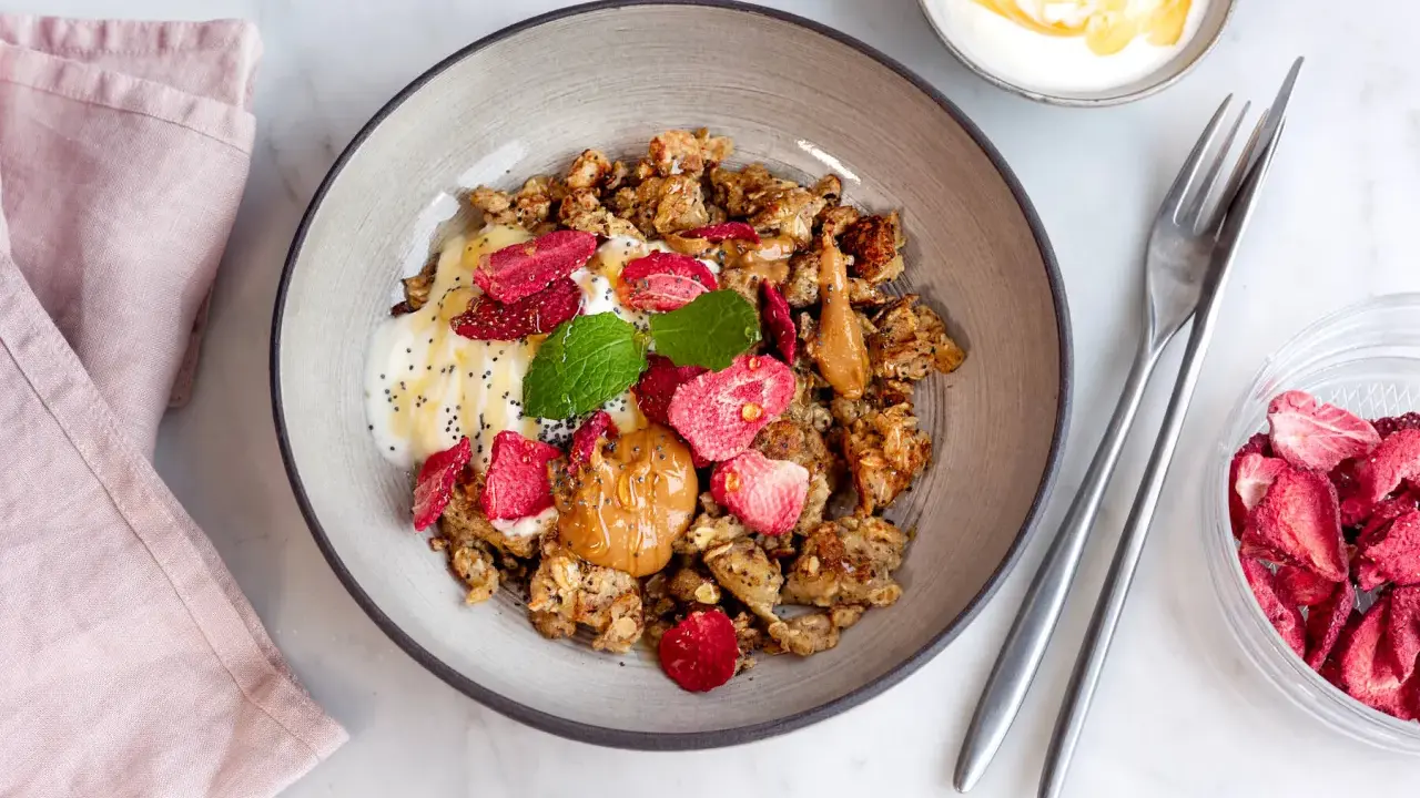 En skål med granola, yoghurt, jordgubbar, jordnötssmör och chiafrön. En perfekt nyttig frukost för en bra start på dagen.