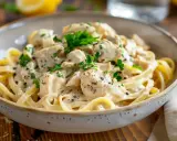 En krämig kyckling pasta med färsk persilja och svartpeppar, serverad i en rustik skål.