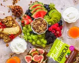 En lyxig frukostbricka med frukt, nötter, yoghurt och granola. Vattenmelon, kiwi, bär, vindruvor, banan och fikon skapar en färgsprakande och hälsosam start på dagen.