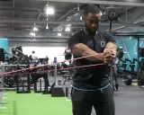 Man utför pallof press med gummiband i ett gym.