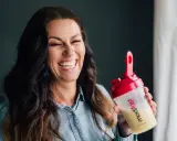 Glad kvinna skrattar med en shaker från Modifast diet.