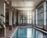 Inre poolområde med stora fönster och grönska utanför, perfekt för ett yoga retreat i Stockholm.