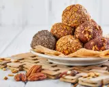 En hög med hemgjorda proteinbollar, täckta av frön och havre. Ett perfekt proteinbollar recept för ett snabbt mellanmål.