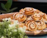 En hög med gyllene, nybakade kanelbullar, strösslade med pärlsocker. Perfekta för fikat, dessa nyttiga bullar ser oemotståndliga ut.