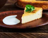 En bit fluffig, nyttig cheesecake med mynta och en klick grädde på en lerbricka.