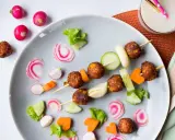 Vegetariska mat för barn på ett fat med köttbullar, gurka, morötter och rädisor. En festlig och hälsosam måltid!