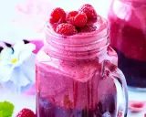 En härlig smoothie i ett glas med färska hallon på toppen. Ett perfekt smoothie recept för en solig dag.