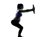 Gravid kvinna tränar med en pilatesring. Hon gör en knäböj och håller ringen framför sig med raka armar.