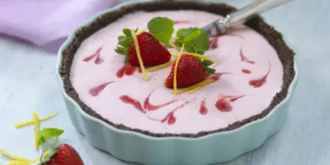 En läcker jordgubbstårta, perfekt för att baka utan socker. Garnerad med färska jordgubbar, citronskal och mynta.
