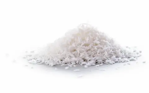 En hög med kokosflingor, ett nyttigt och mångsidigt livsmedel som kan användas i bakning och matlagning.