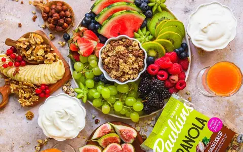 En lyxig frukostbricka med frukt, nötter, yoghurt och granola. Vattenmelon, kiwi, bär, vindruvor, banan och fikon skapar en färgsprakande och hälsosam start på dagen.