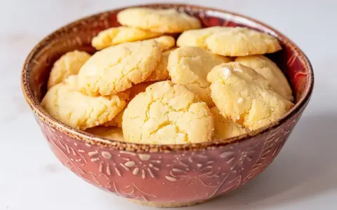 En skål fylld med gyllene, krispiga mandelmusslor glutenfria. Perfekta för fikat!
