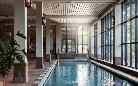 Inre poolområde med stora fönster och grönska utanför, perfekt för ett yoga retreat i Stockholm.
