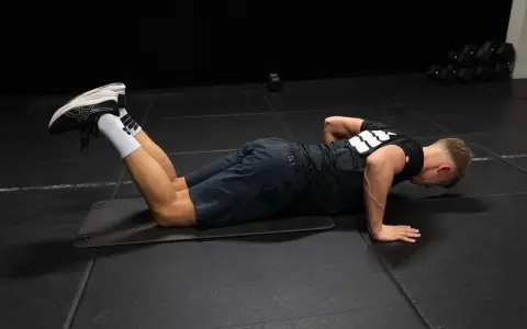 Man utför armhävningar på knä som en del av rehab axel.