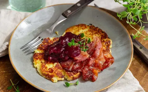 Stekta potatisbullar av potatismos, toppade med lingonsylt och knaperstekt bacon. En klassisk svensk rätt som väcker aptiten.