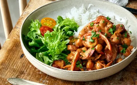En krämig kycklinggryta med kikärtor och paprika serveras med ris och en fräsch sallad. Perfekt nyttig vardagsmat för hela familjen.