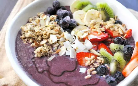 En härlig acai bowl med granola, jordgubbar, blåbär, kiwi och banan. Perfekt för ett snabbt och nyttigt frukost recept.