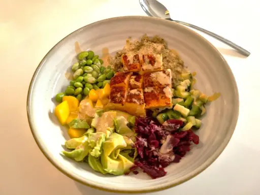 En skål med lax, quinoa, edamamebönor, mango, avokado och rödbetor. Ett perfekt recept nyttig mat för en hälsosam lunch.
