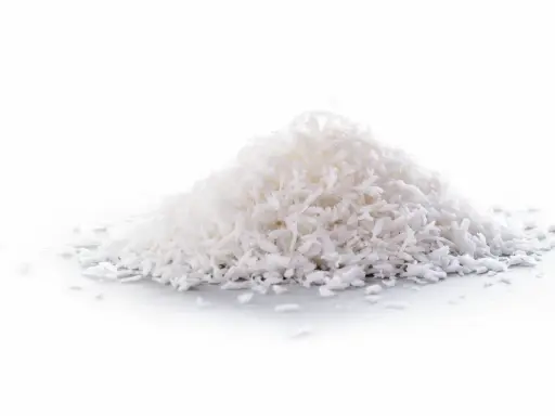 En hög med kokosflingor, ett nyttigt och mångsidigt livsmedel som kan användas i bakning och matlagning.