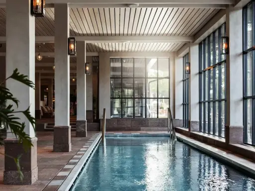 Inre poolområde med stora fönster och grönska utanför, perfekt för ett yoga retreat i Stockholm.