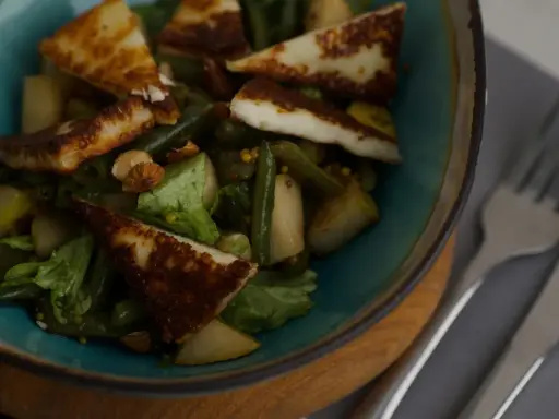 En sallad med grillad halloumi, gröna bönor, päron och nötter. En proteinrik och smakrik rätt.