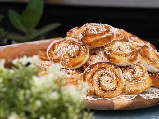 En hög med gyllene, nybakade kanelbullar, strösslade med pärlsocker. Perfekta för fikat, dessa nyttiga bullar ser oemotståndliga ut.