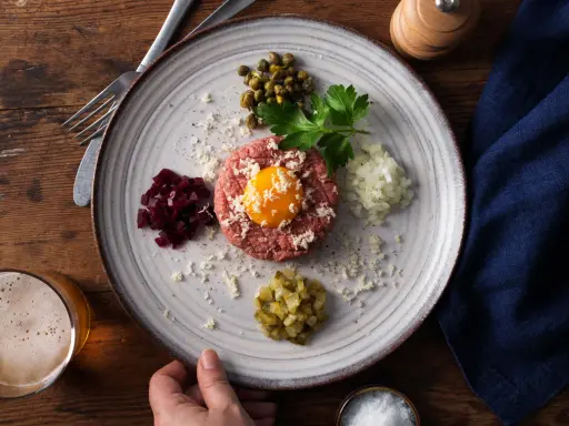 En vacker råbiff med äggula, kapris, hackad lök, rödbetor och gurka. Perfekt för den som är gravid och längtar efter något gott.