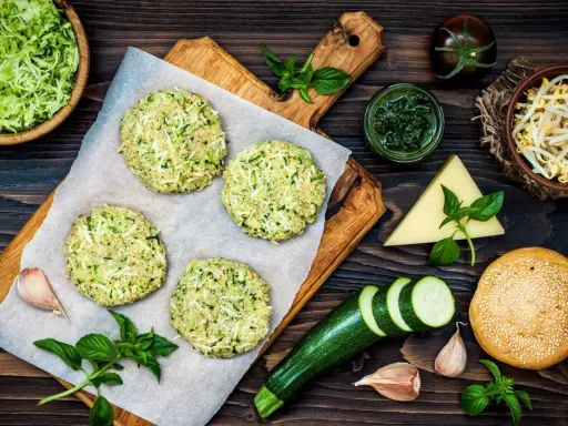 Zucchinibiffar på bakplåtspapper, ingredienser för proteinrik mat med lite kalorier recept.