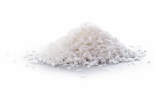 En hög med kokosflingor, ett nyttigt och mångsidigt livsmedel som kan användas i bakning och matlagning.