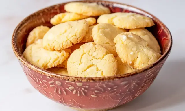 En skål fylld med gyllene, krispiga mandelmusslor glutenfria. Perfekta för fikat!