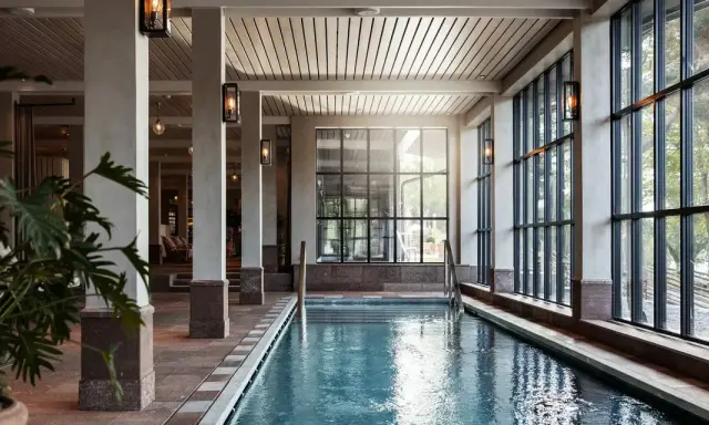 Inre poolområde med stora fönster och grönska utanför, perfekt för ett yoga retreat i Stockholm.