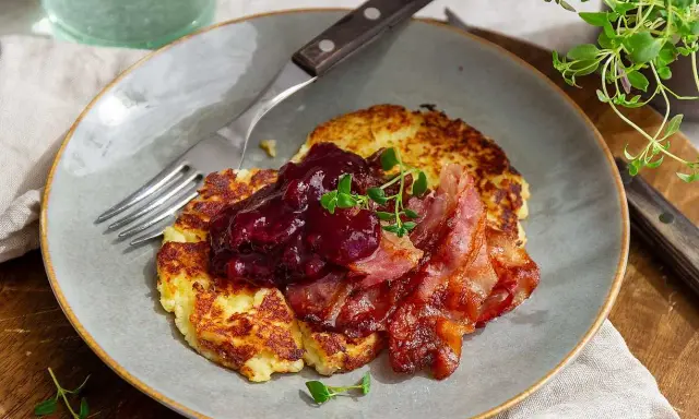 Stekta potatisbullar av potatismos, toppade med lingonsylt och knaperstekt bacon. En klassisk svensk rätt som väcker aptiten.