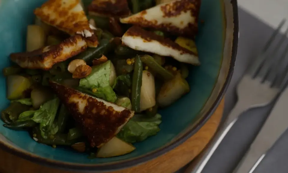 En sallad med grillad halloumi, gröna bönor, päron och nötter. En proteinrik och smakrik rätt.