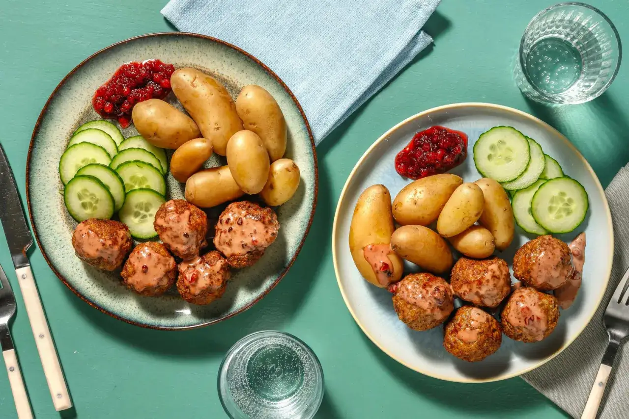 Två tallrikar med köttbullar, potatis, gurka och lingonsylt. Ett perfekt middagstips vardag för hela familjen.
