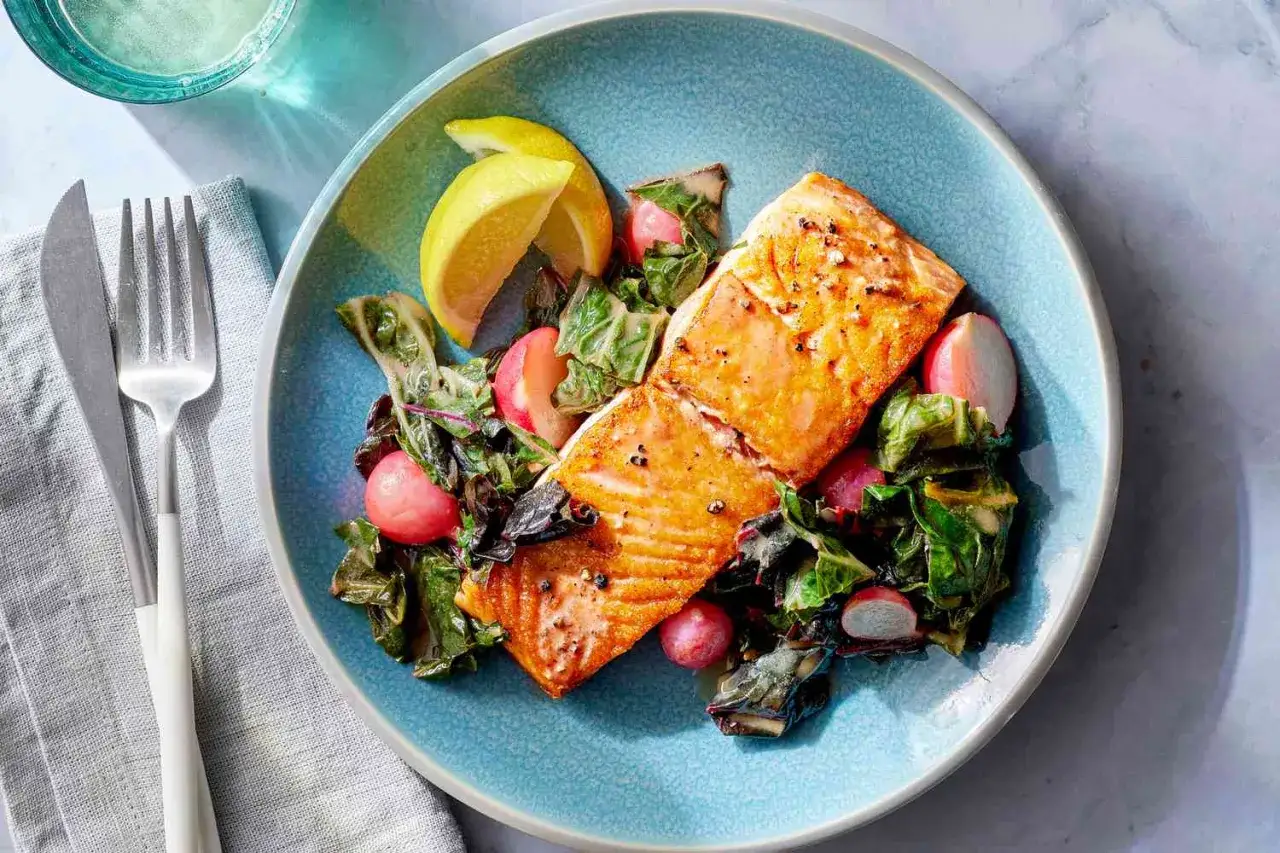 Två saftiga laxfiléer med en fräsch sallad av mangold och rädisor, toppad med citronklyftor. Perfekt nyttig fredagsmat!