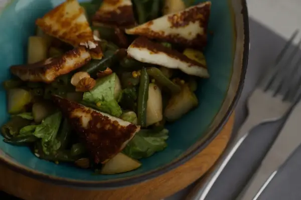 En sallad med grillad halloumi, gröna bönor, päron och nötter. En proteinrik och smakrik rätt.